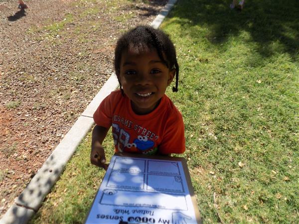 Student smiling with clipboard project in hand